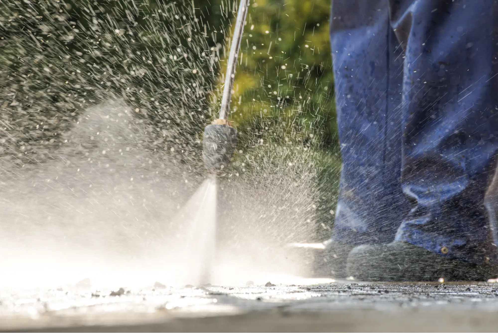 Person power washing a sidewalk